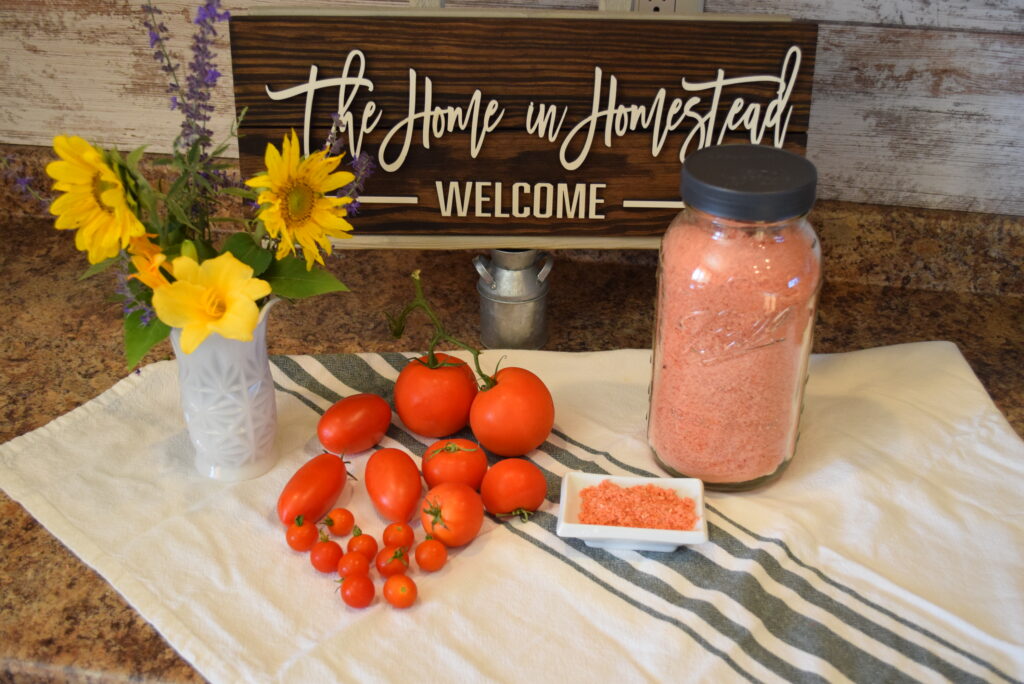 Freeze Dried Tomato Scraps for Tomato Powder in Jar and dish in front of a The Home in Homestead Sign